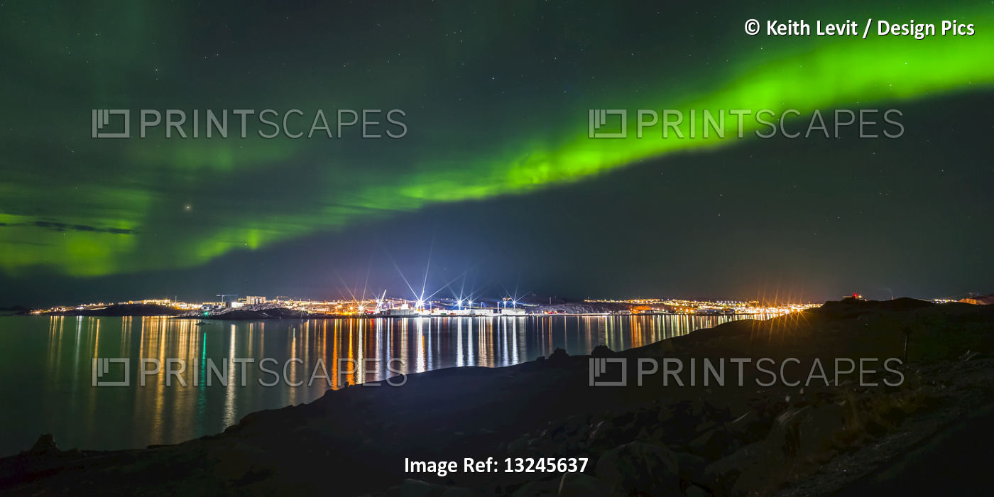 Northern Lights over the glowing city of Nuuk; Nuuk, Sermersooq, Greenland