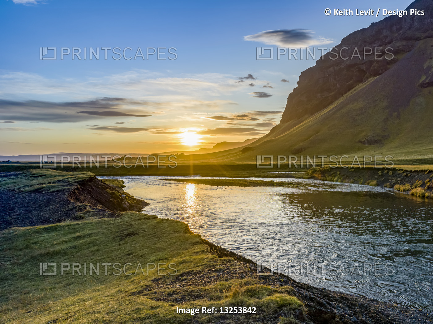 Beautiful sunrise over a river and lush landscape in Southern Iceland; ...