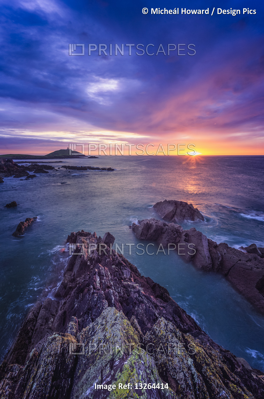 Sunrise along the Irish coast with rock formations in the foreground and ...