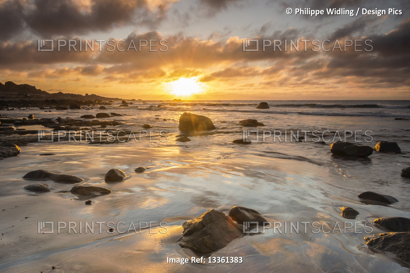 Beautiful sunset on the Pacific ocean photographed from a rocky beach; Atacama, ...