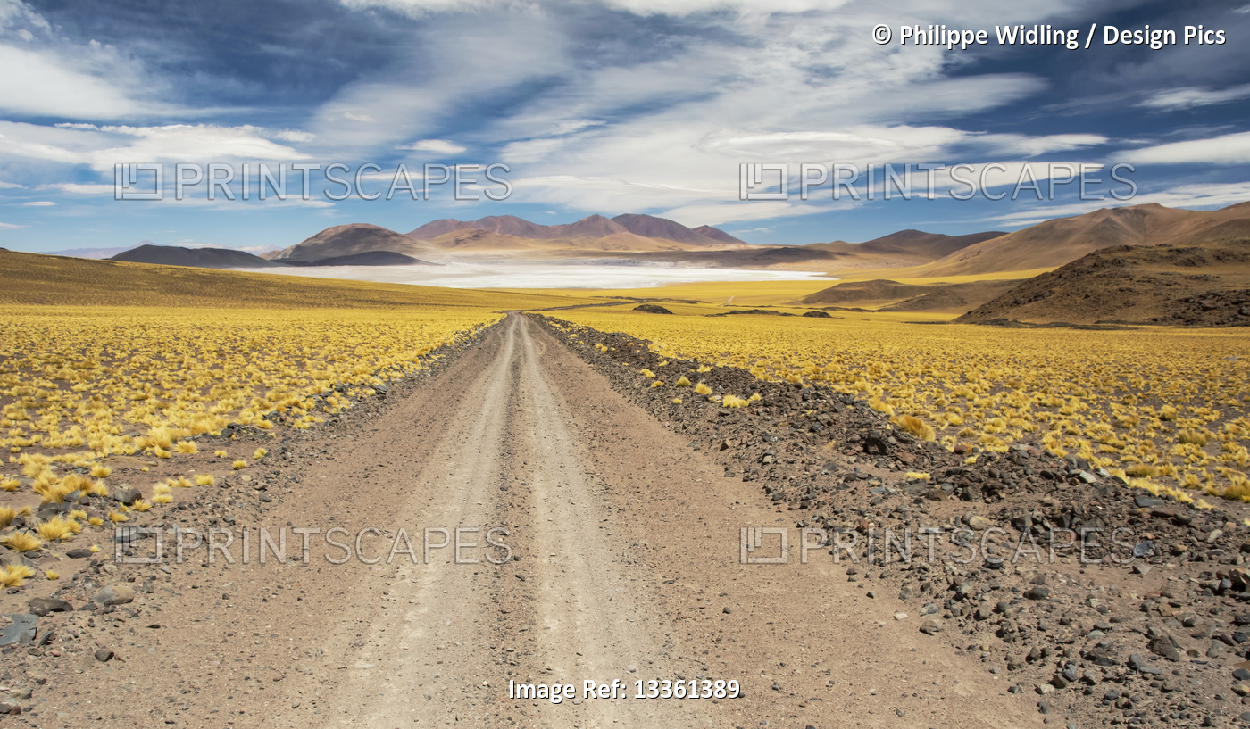 Gravel road leads to a high altitude laguna in the middle of a colourful ...