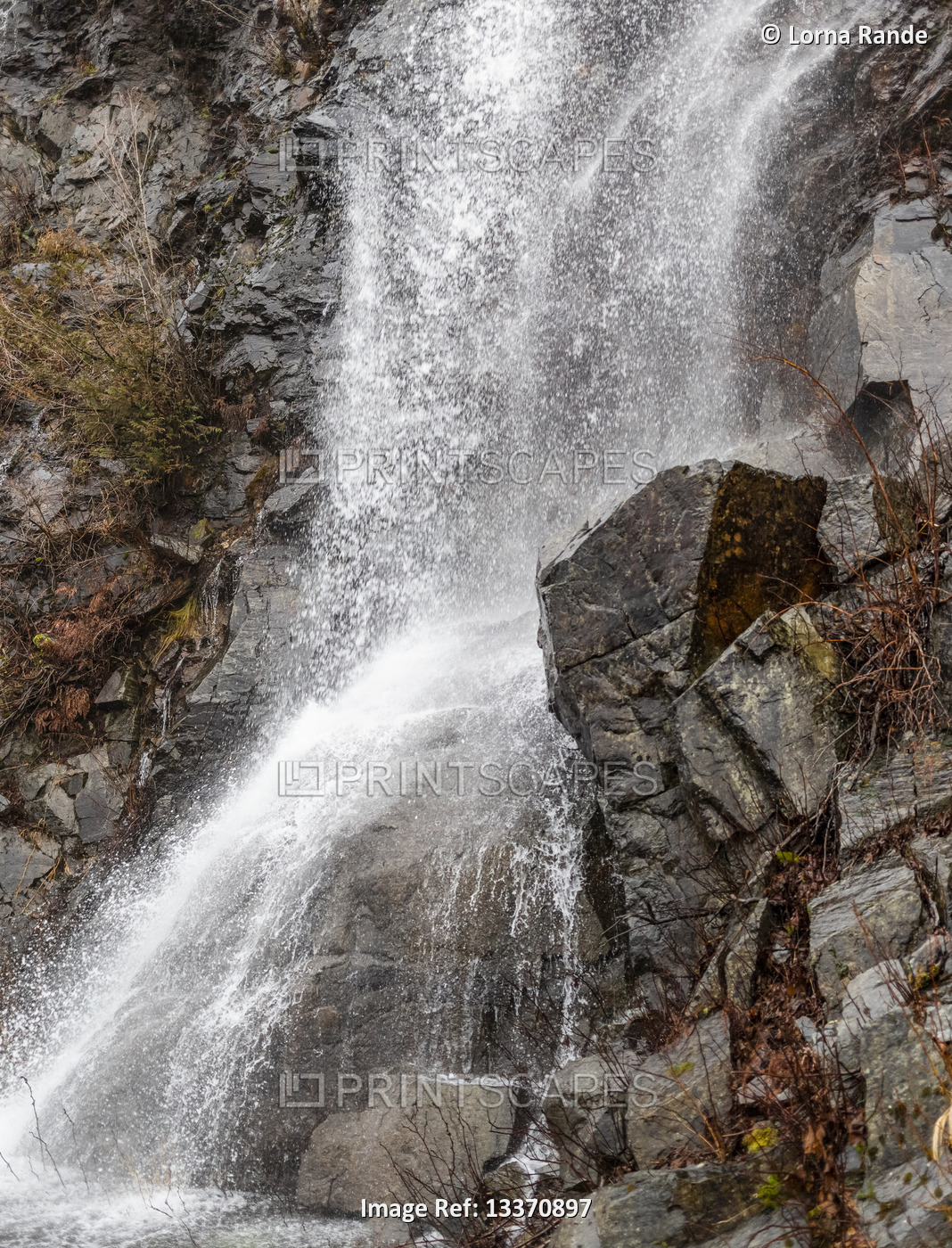 Splashing waterfall over rugged rock wall, Village of Harrison Hot Springs; ...