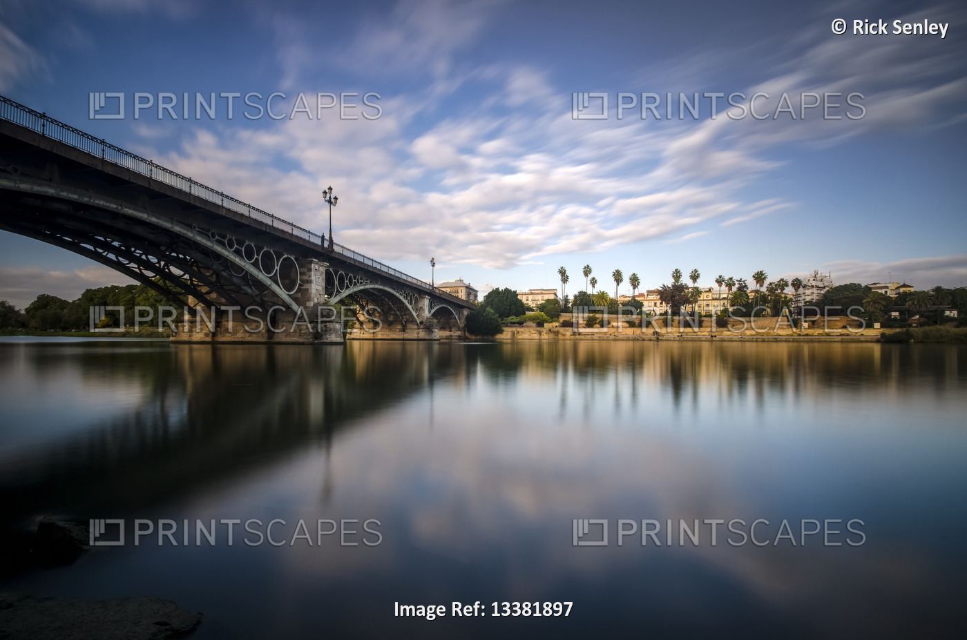 Reflection of a river and Guadalquivir bridge at dusk; Seville, Andalucia, Spain