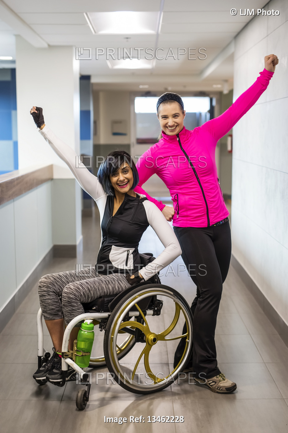 A paraplegic woman and her trainer do a celebratory pose for the camera while ...