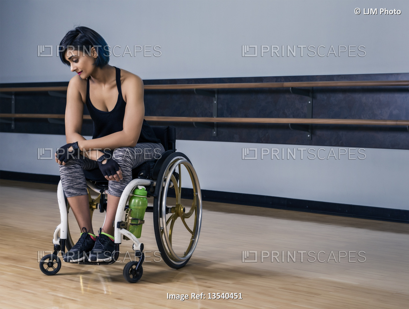 A paraplegic woman looking discouraged while taking a break from working out in ...