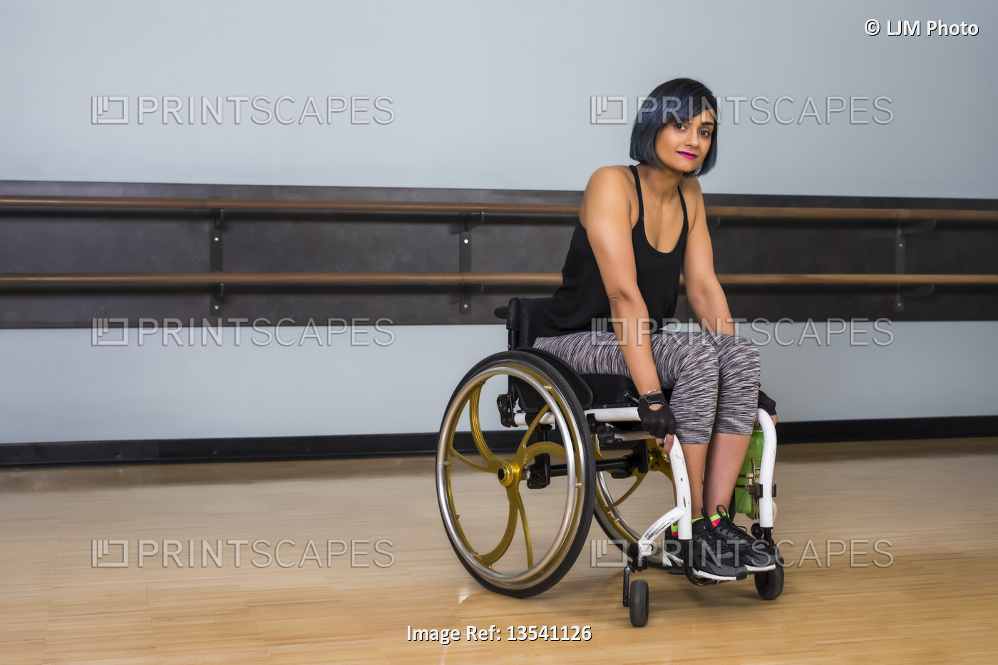 A paraplegic woman taking a break in a gymnasium after working out in a ...