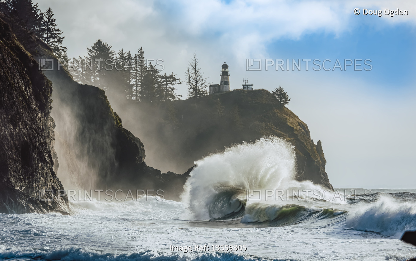 Cape Disappointment Light with large waves crashing in onto the beach below, ...