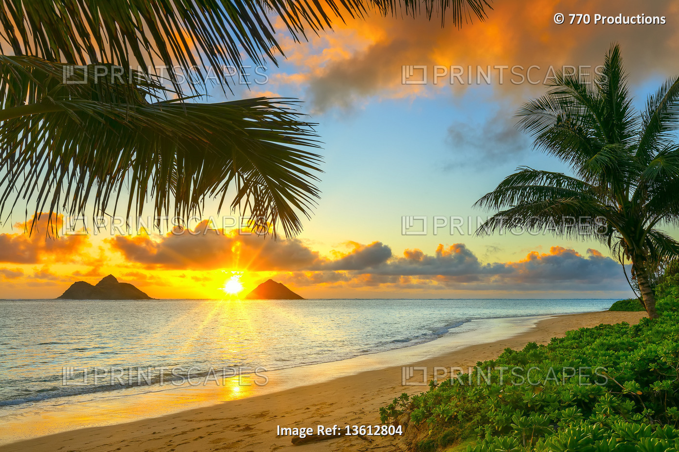 Sunrise viewed from Lanikai Beach with a view of the Mokulua Islands off the ...