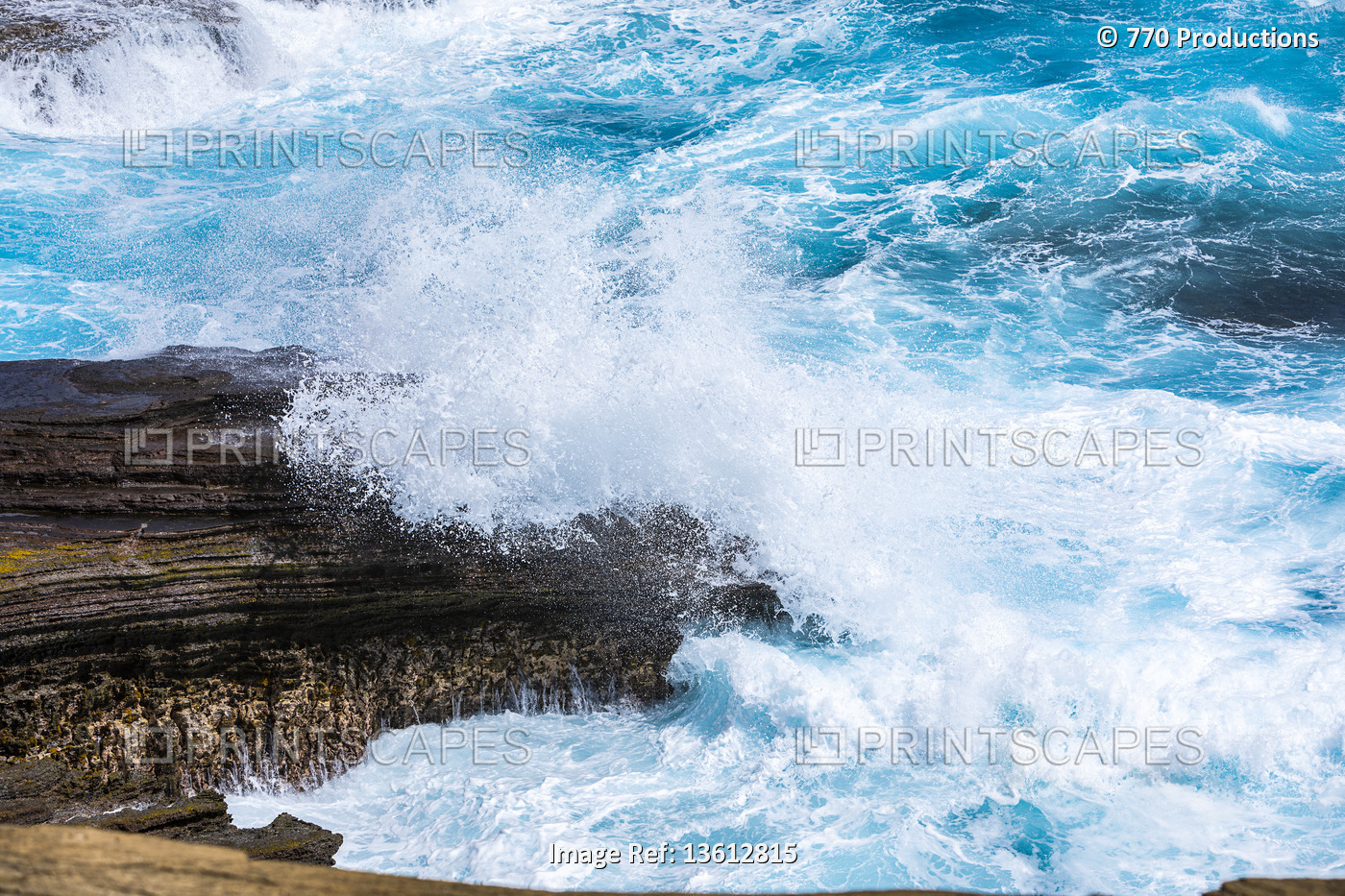 Splashing waves of blue water into rock on the coast of Oahu, Banzai Pipeline; ...
