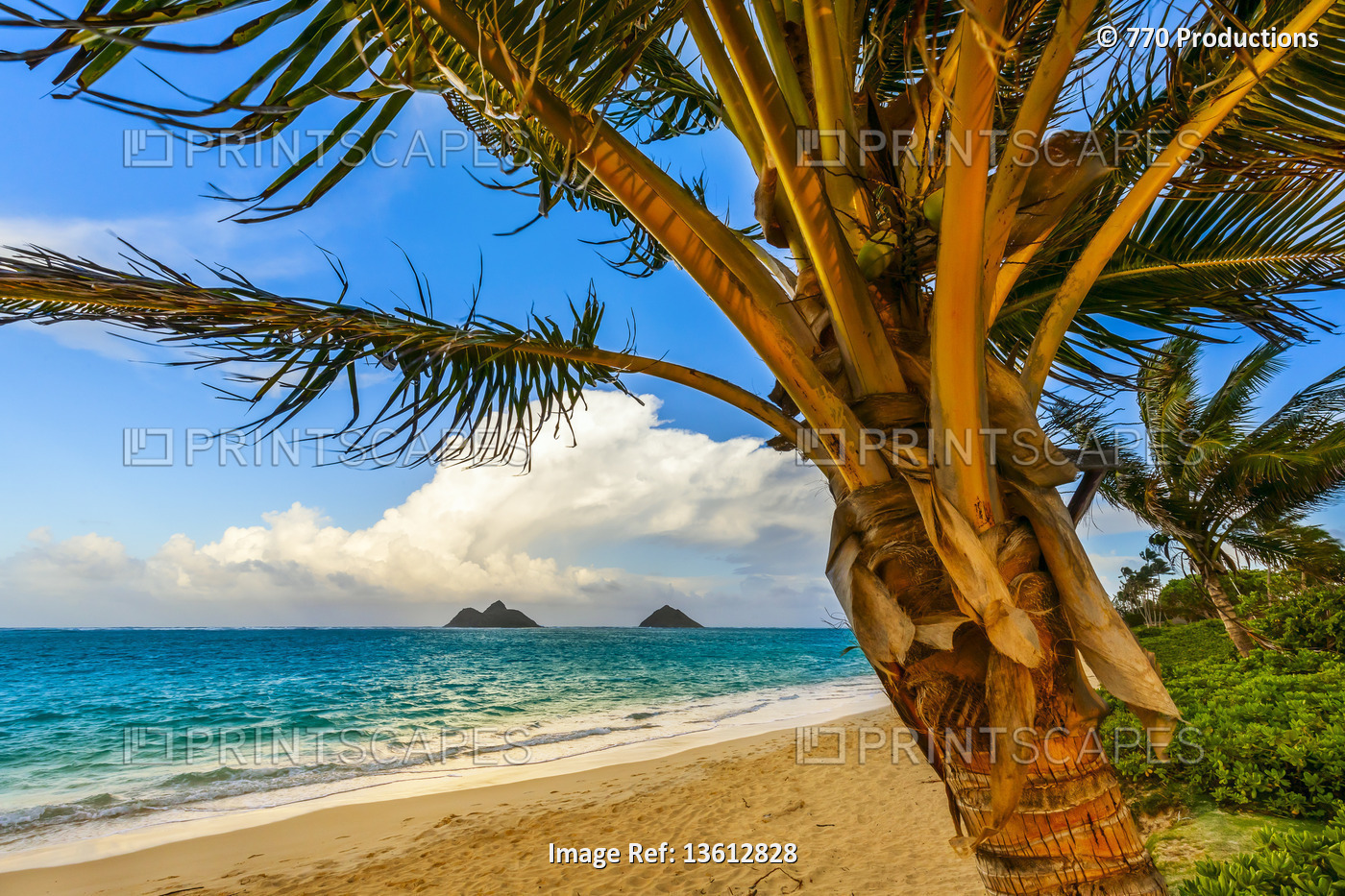 The golden sand and surf on Lanikai Beach with a view of the Mokulua Islands ...