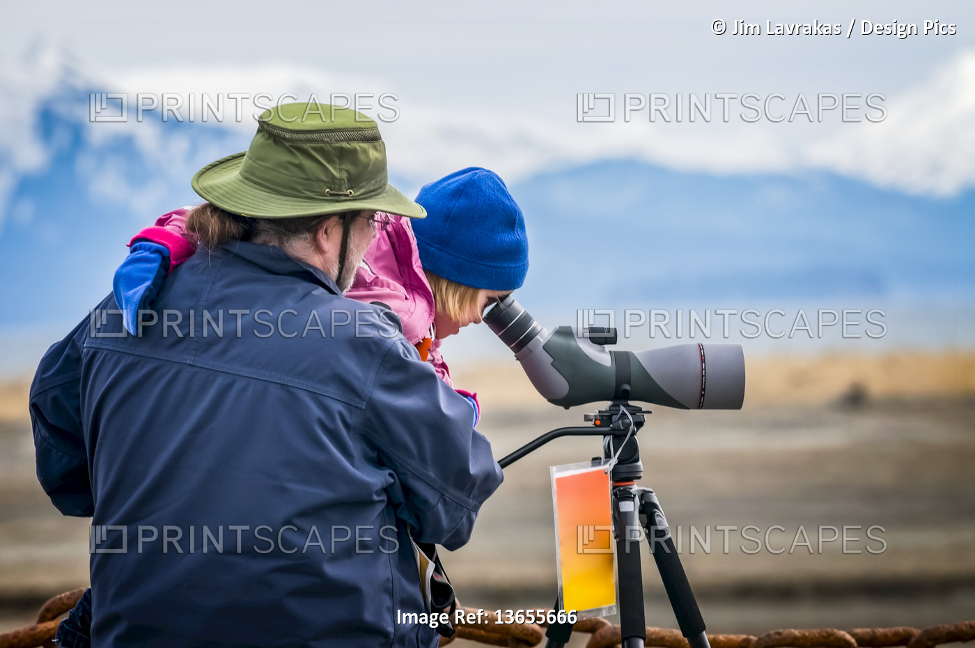 A man holds his daughter to look through a spotting scope during the 21st ...