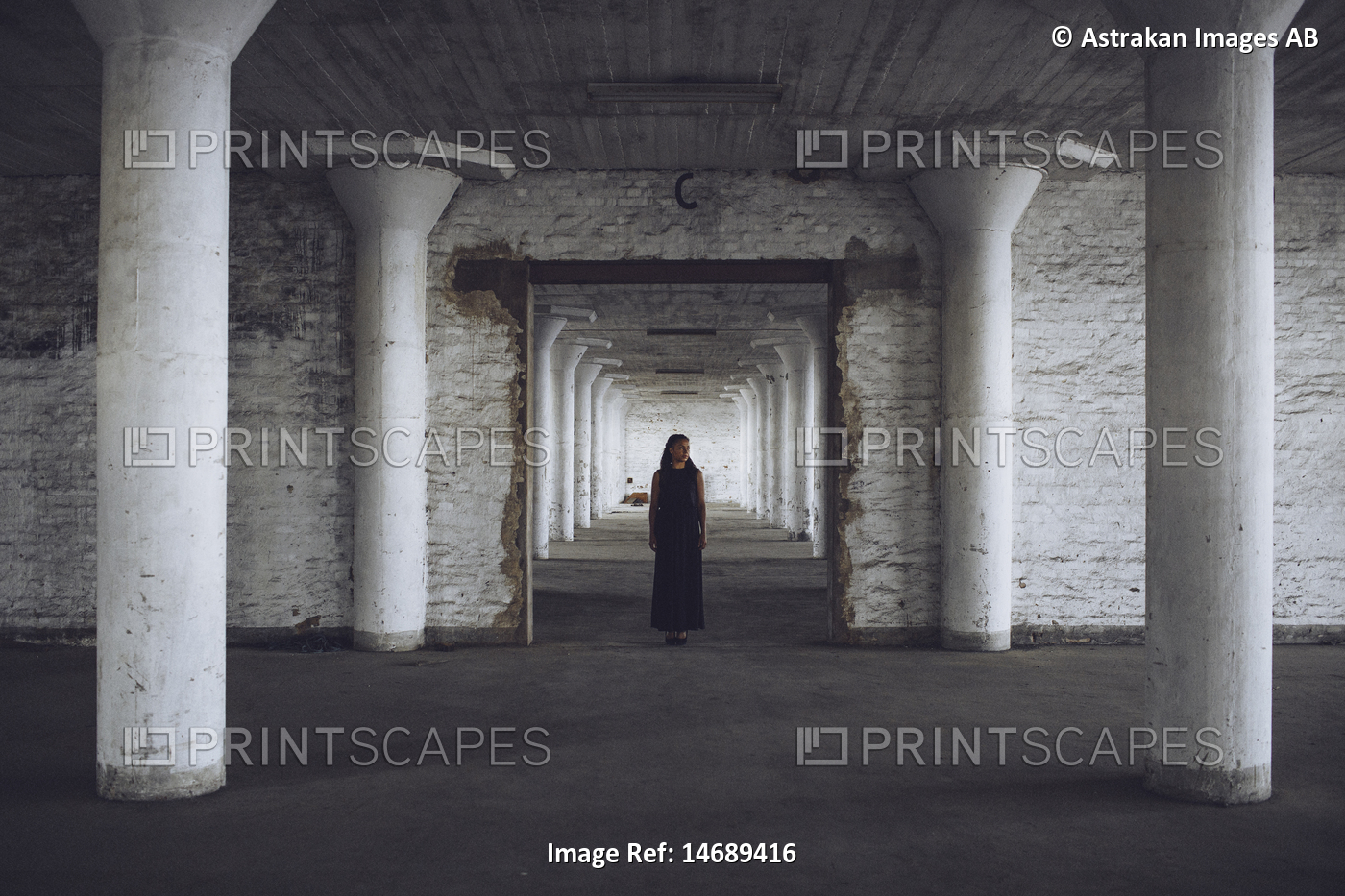 Mid distance of young woman standing in old factory