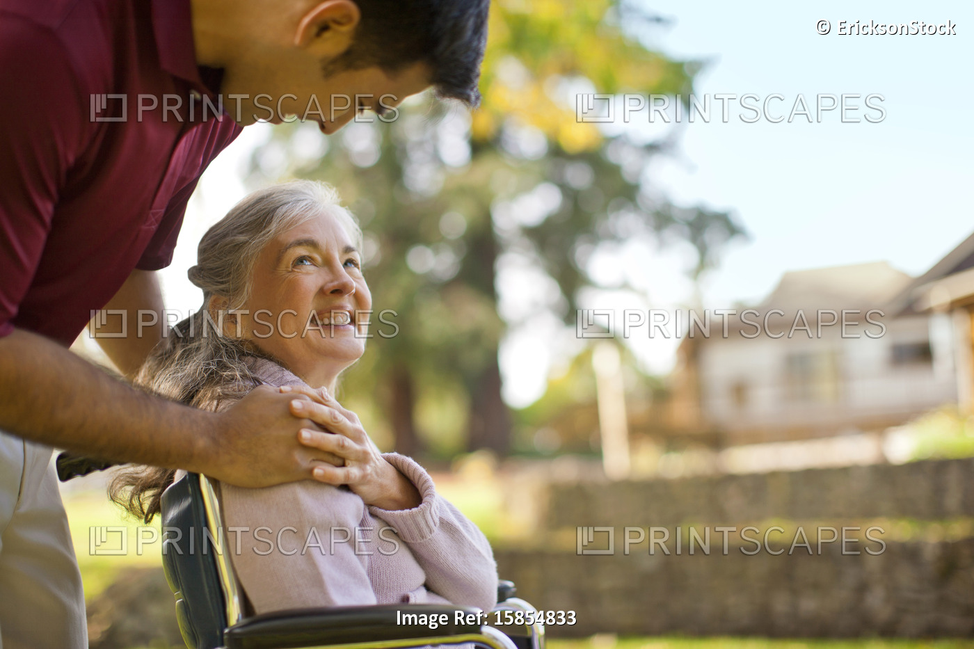 Smiling senior woman being comforted by a male nurse while sitting in a ...