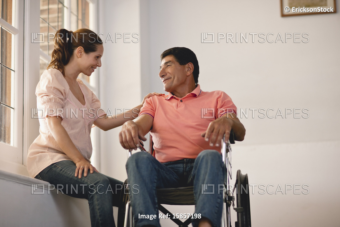 Man in a wheelchair,  talking to his wife.