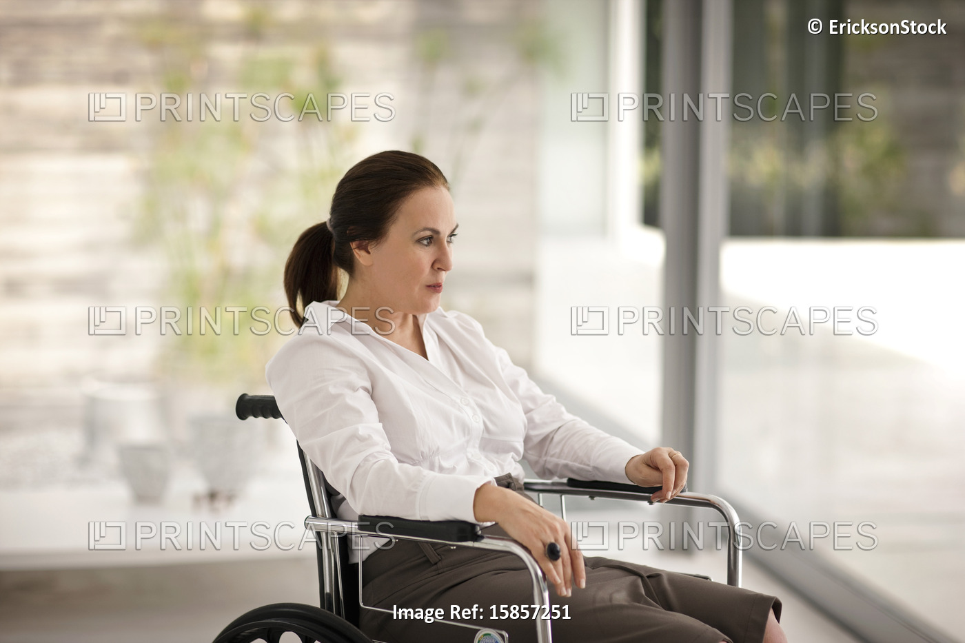 Portrait of senior woman in a wheelchair looking outside.