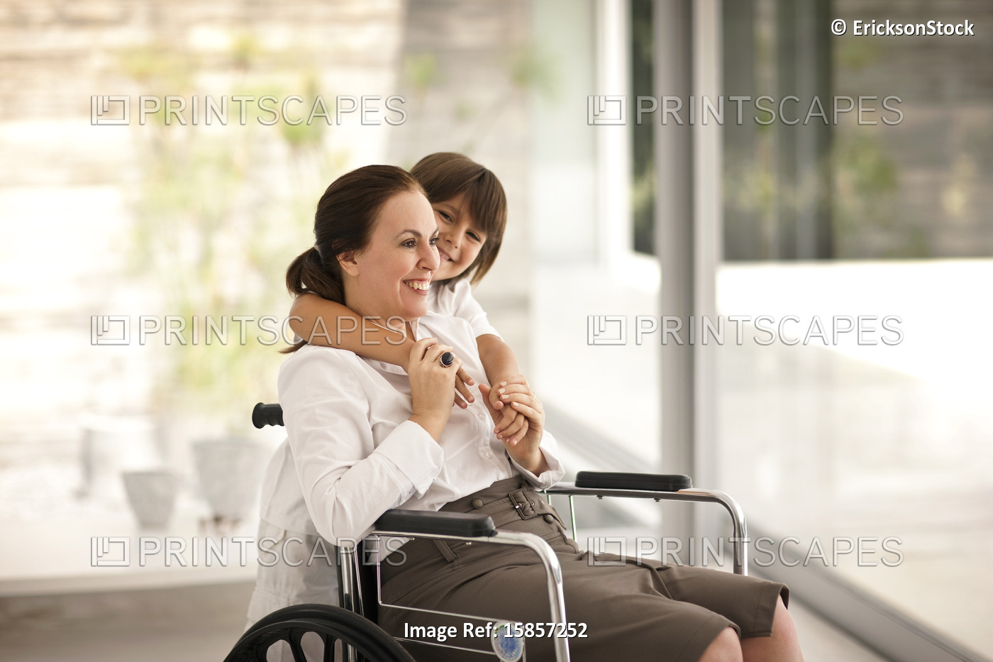 Senior woman in a wheelchair,  receiving a visit from her grandson.