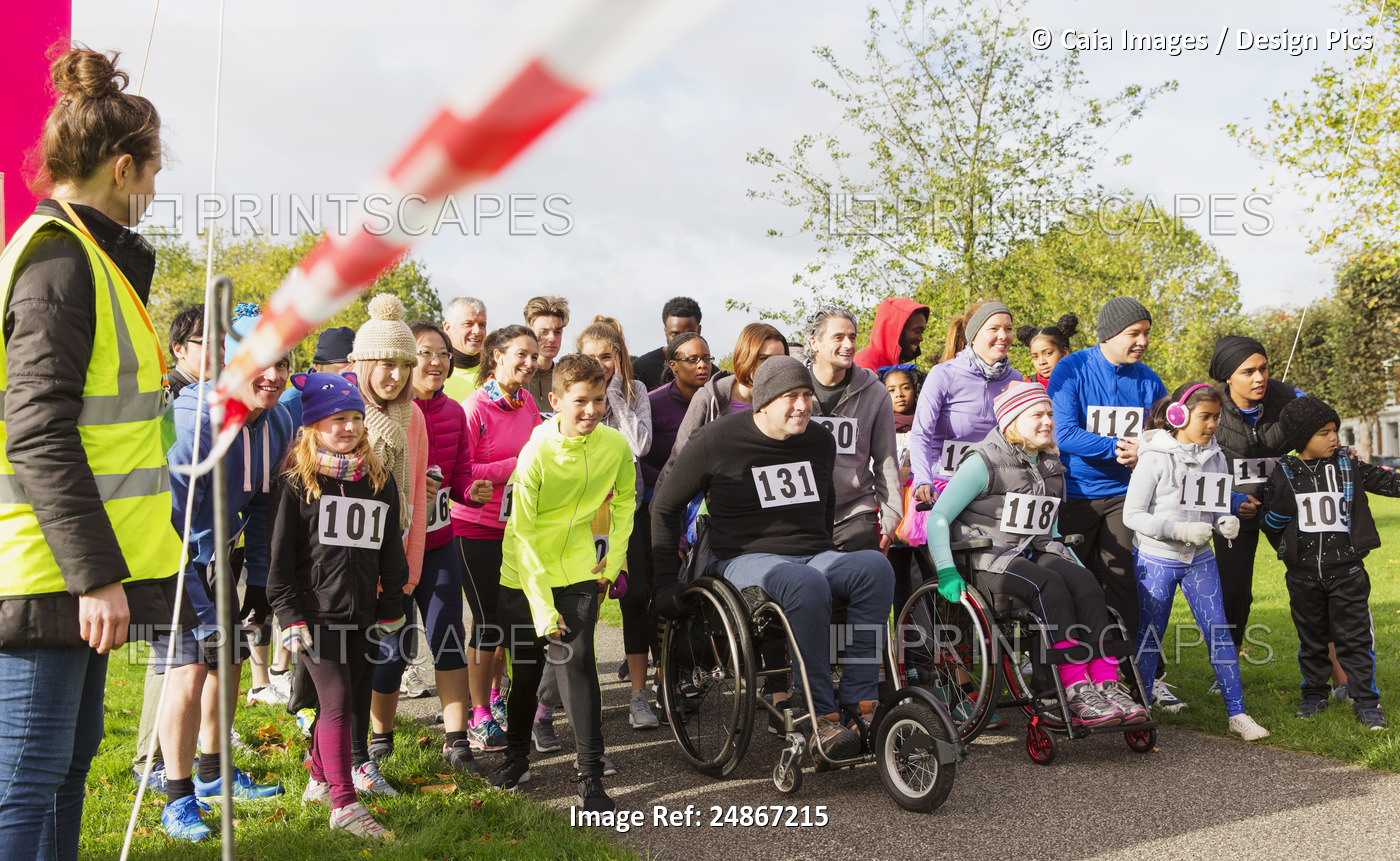 Crowd of runners and people in wheelchairs waiting at charity race starting line