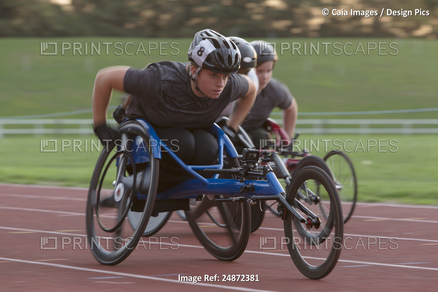 Determined young female paraplegic athlete speeding along sports track in ...
