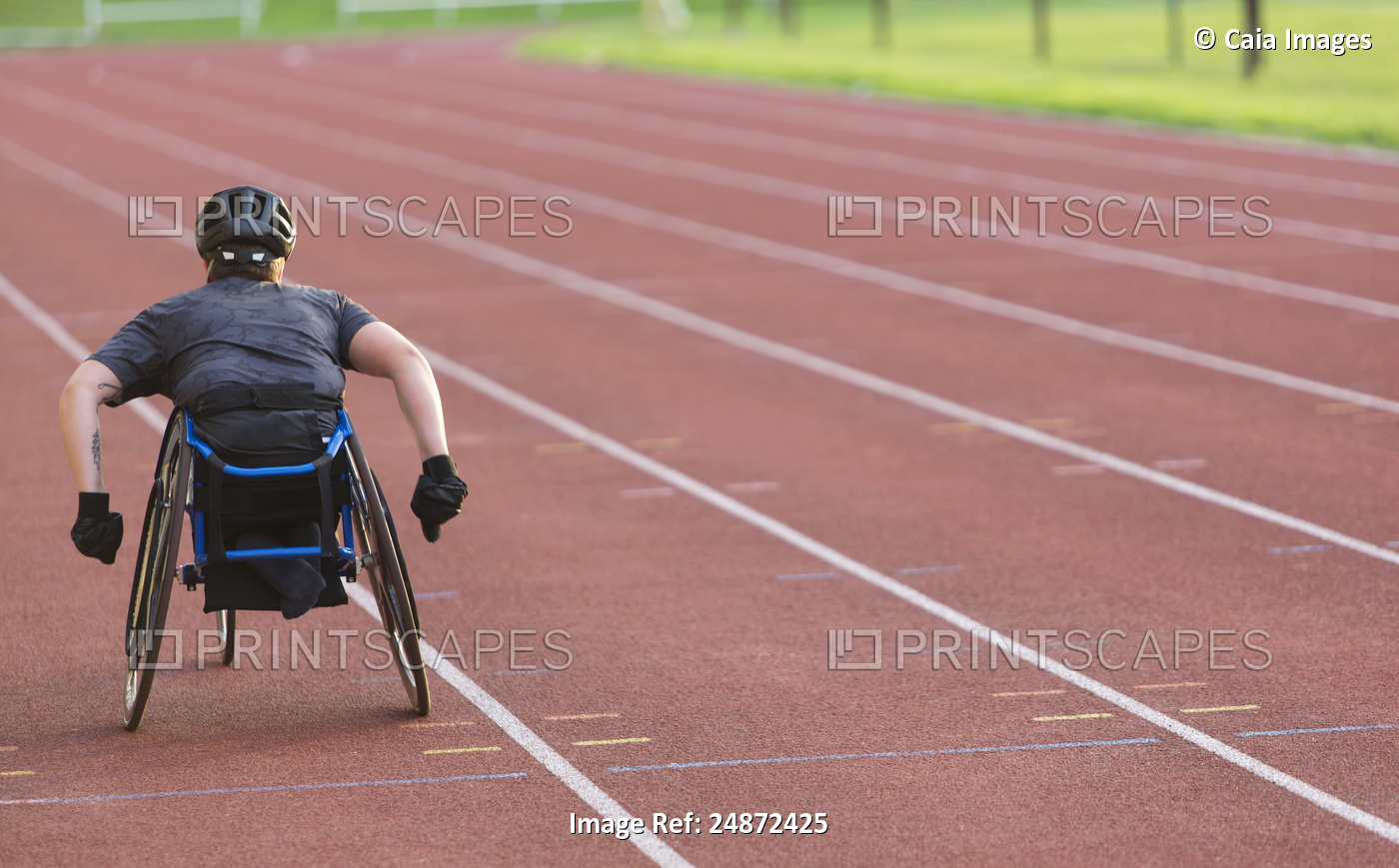 Female paraplegic athlete speeding along sports track in wheelchair race