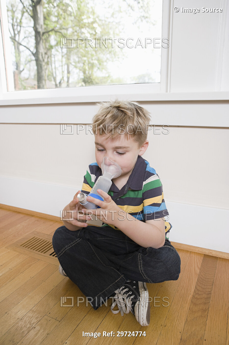 Boy using asthma inhaler with spacer