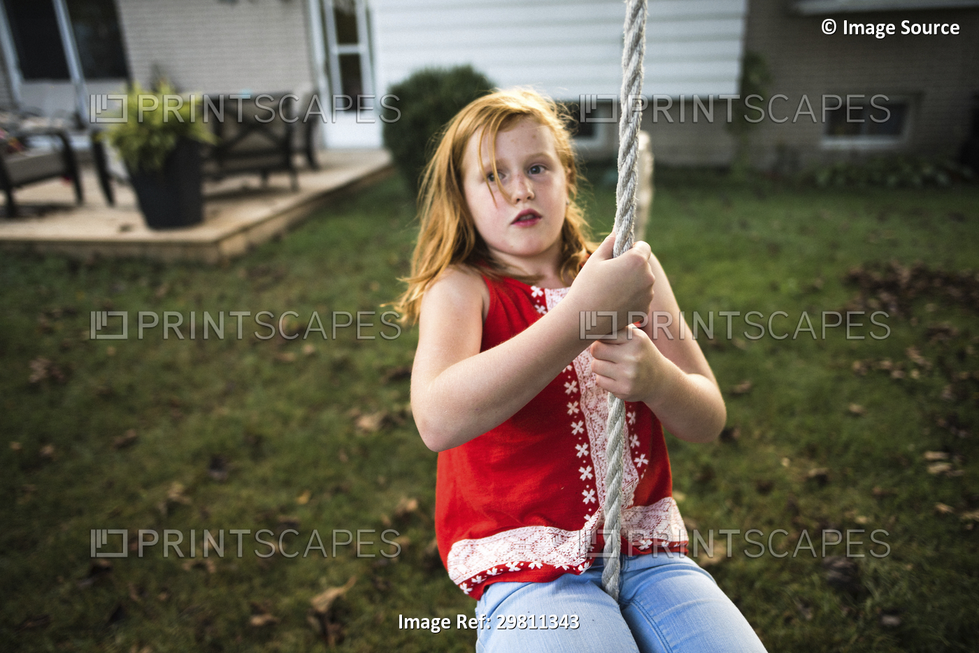 Girl swinging on rope in garden