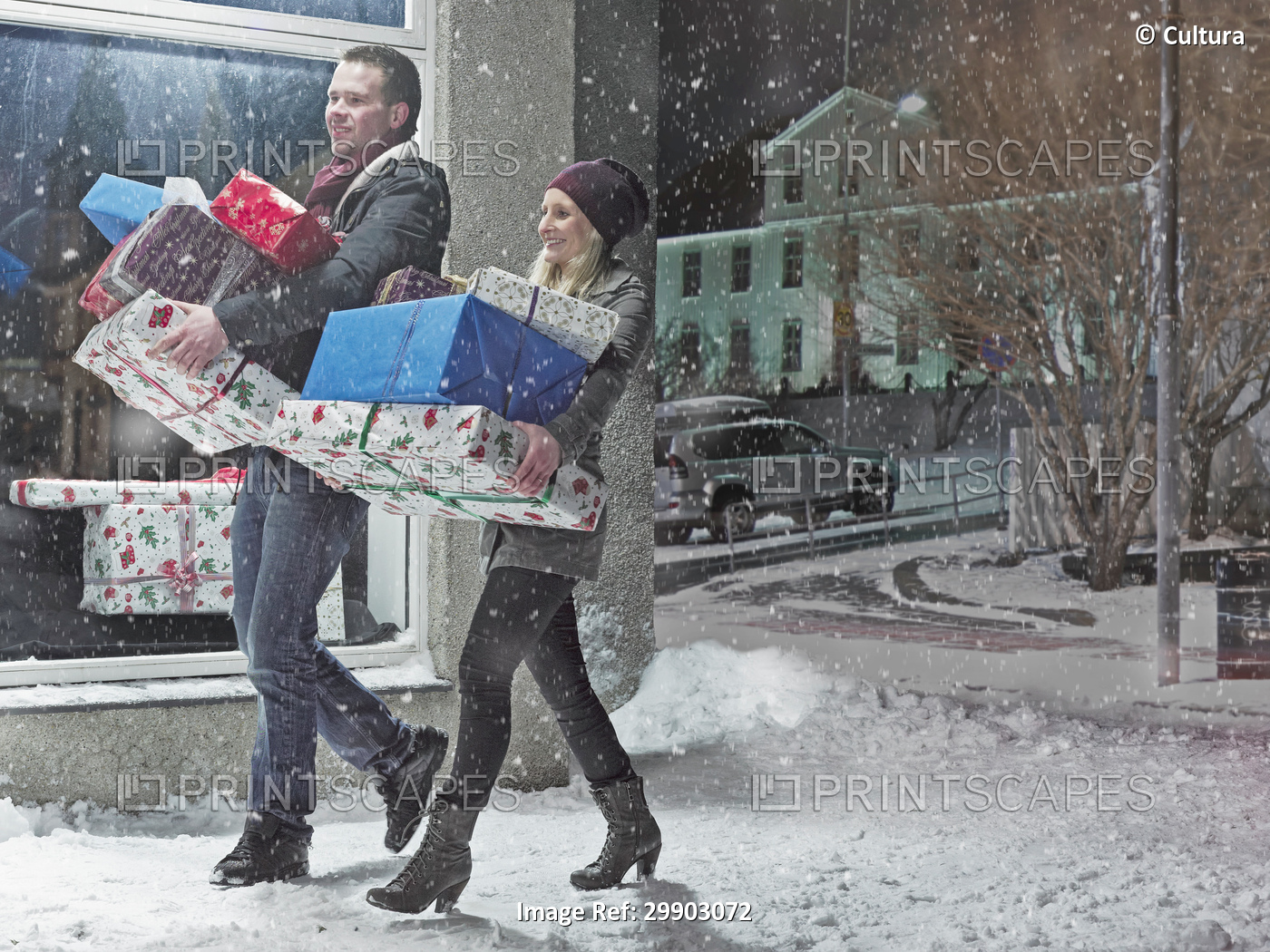 Couple with Christmas gifts in snow