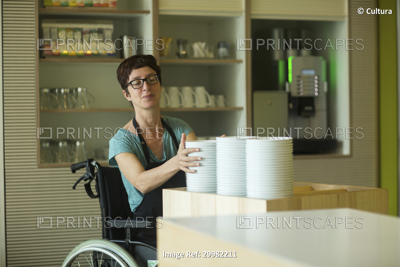 Woman in wheelchair, working in restaurant, stacking bowls