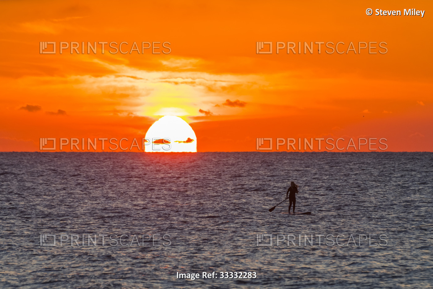 Silhouette of woman paddleboarding on the Atlantic Ocean off the coast of ...