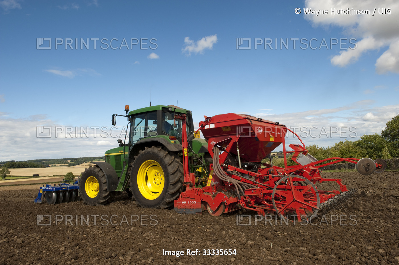 John Deere tractor with front press and rear seed drill planting Oilseed Rape