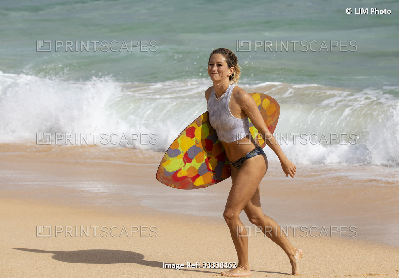 A beautiful young woman who is a professional skimboarder having fun at Sandy ...