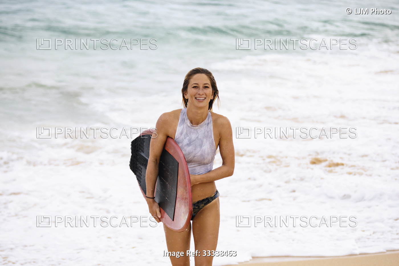 A beautiful young woman who is a professional skimboarder having fun at Sandy ...