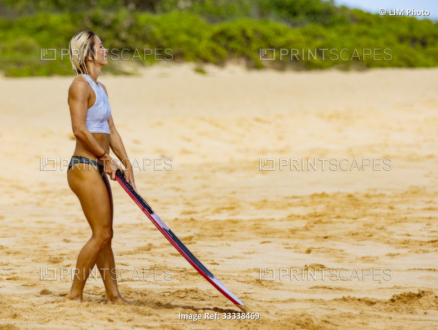 A beautiful young woman who is a professional skimboarder looking out at the ...