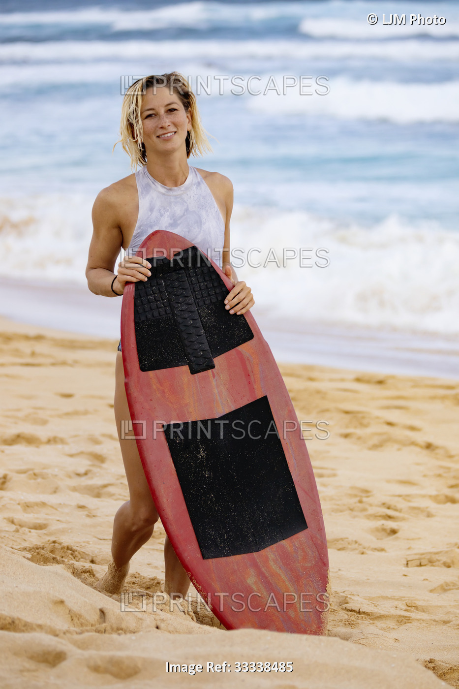 A beautiful young woman who is professional skimboarder posing for the camera ...