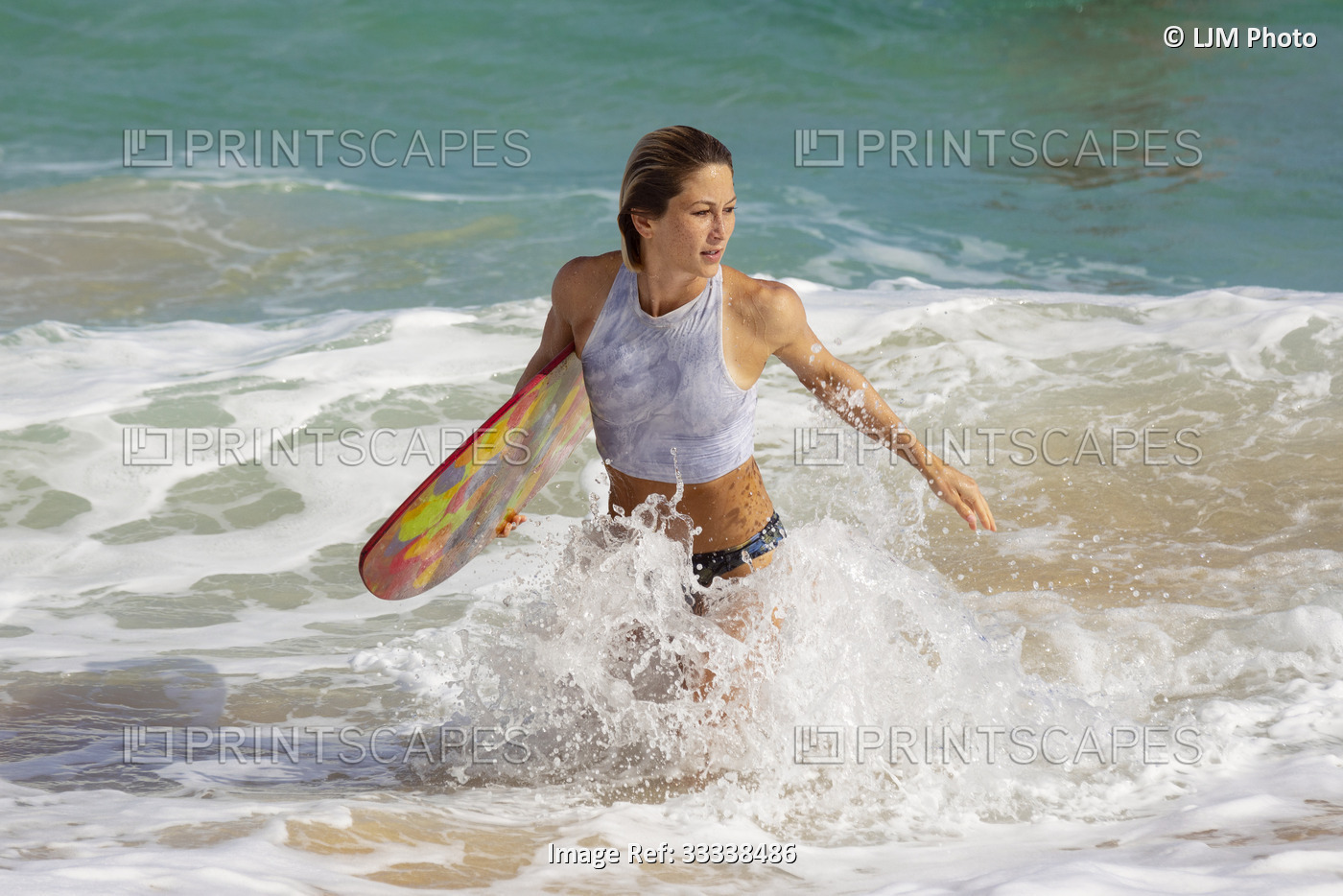 A beautiful young woman who is professional skimboarder having fun at Sandy ...