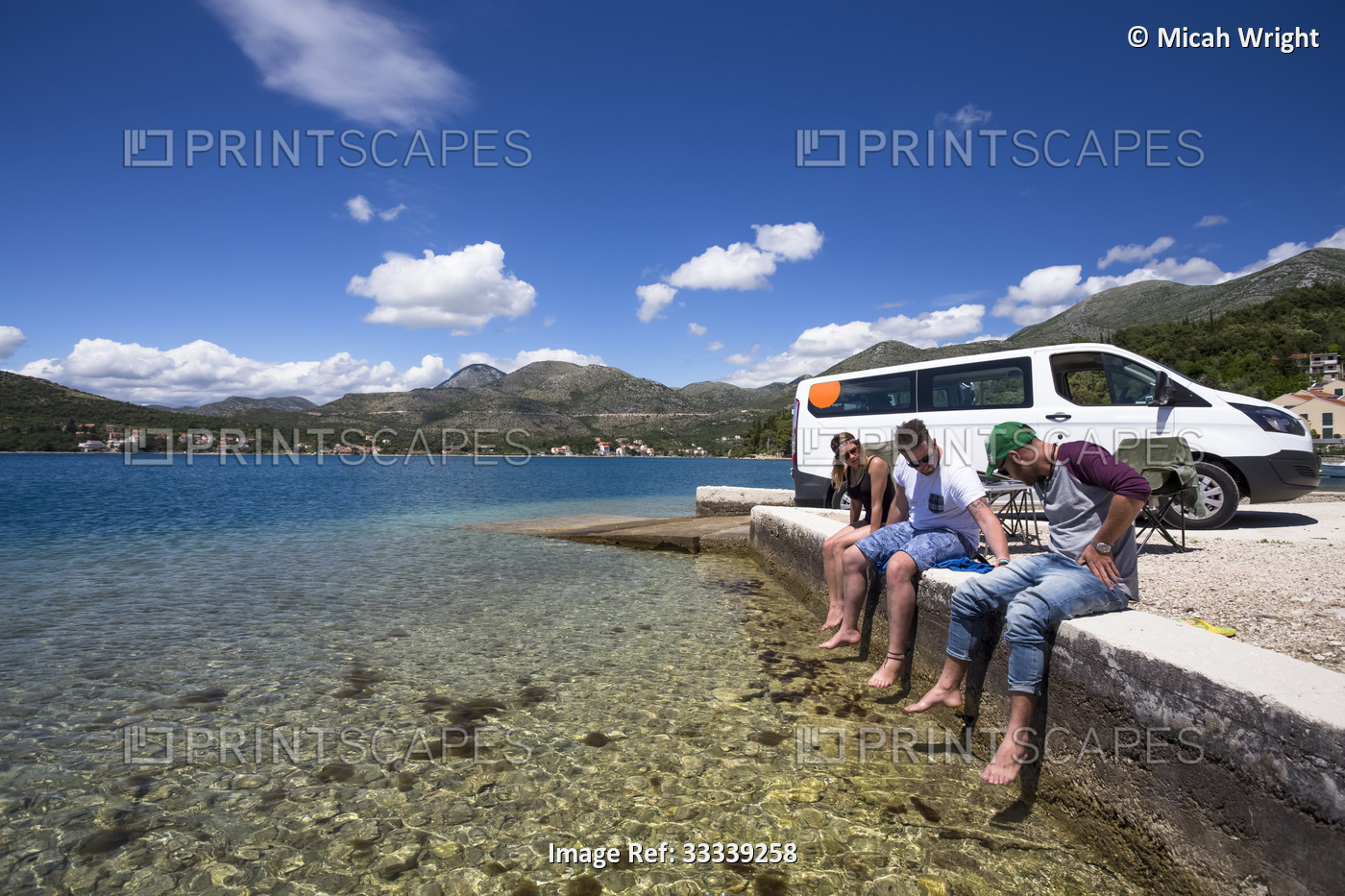 A group of friends sitting outside their camper van as they stop in Slano for ...