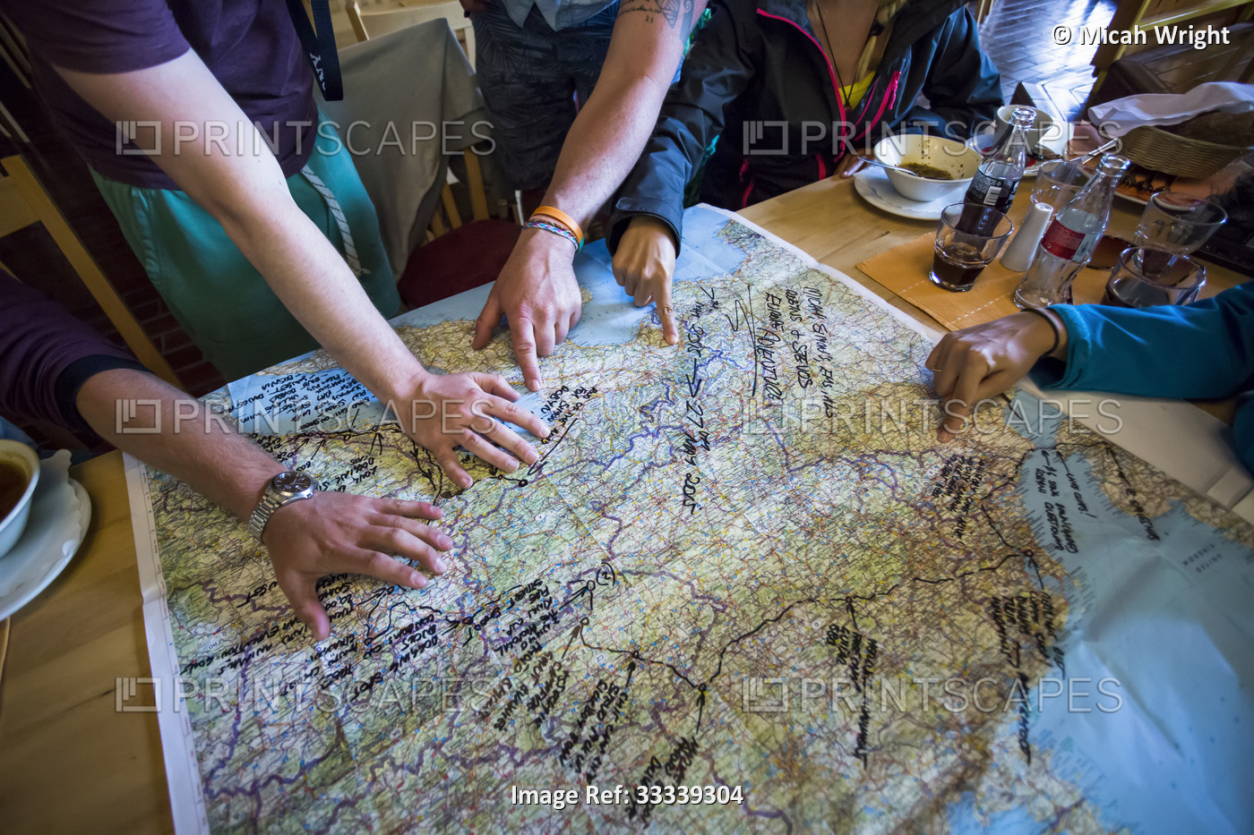 A group of travellers trace their trip on a map; Bled, Slovenia