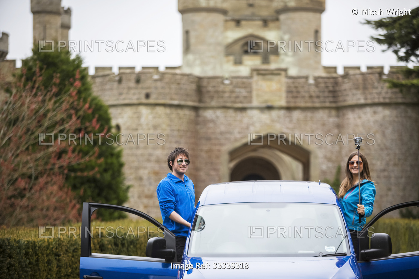 Couple traveling in camper van stop for a selfie in front of Eastnor Castle in ...