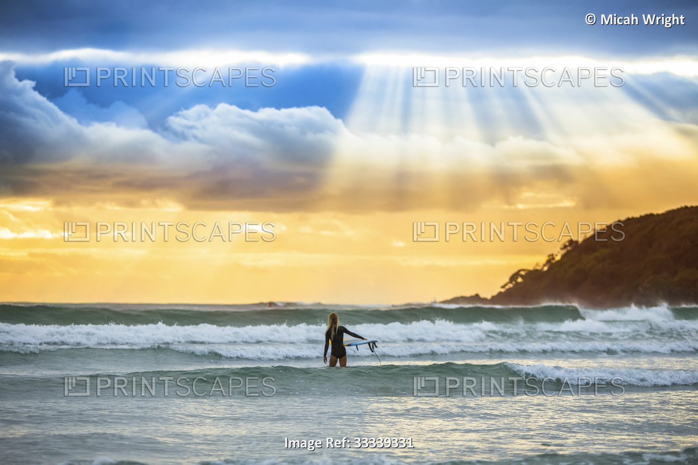 A beautiful sunrise greets a surfer as she prepares and paddle out for an early ...
