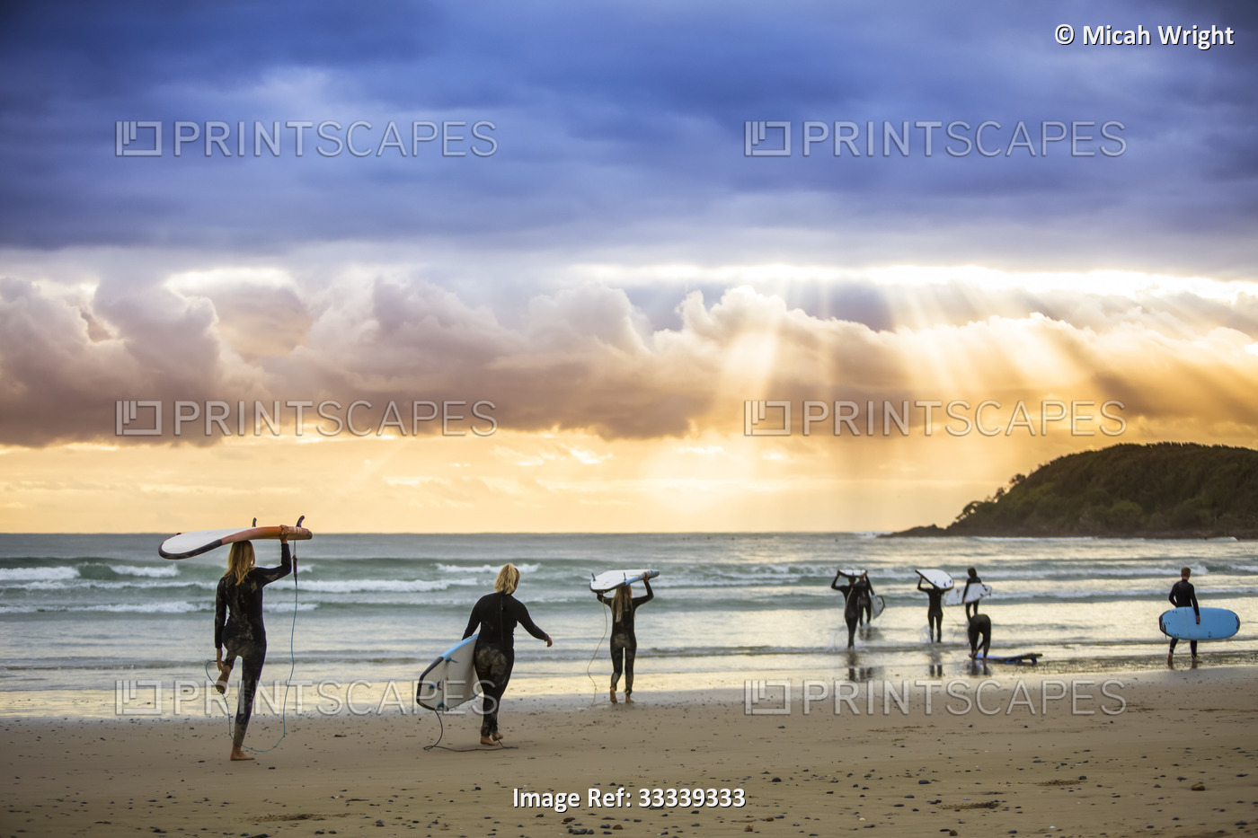 A beautiful sunrise greets surfers as they prepare and paddle out for an early ...