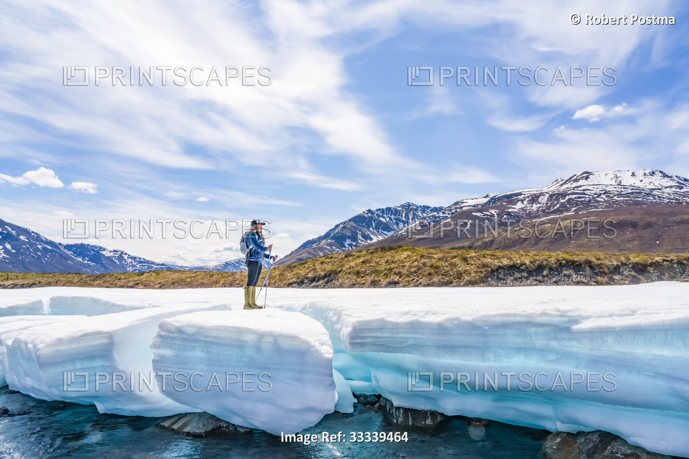 Woman hiking along the Dempster Highway enjoying the scenery, and standing on a ...