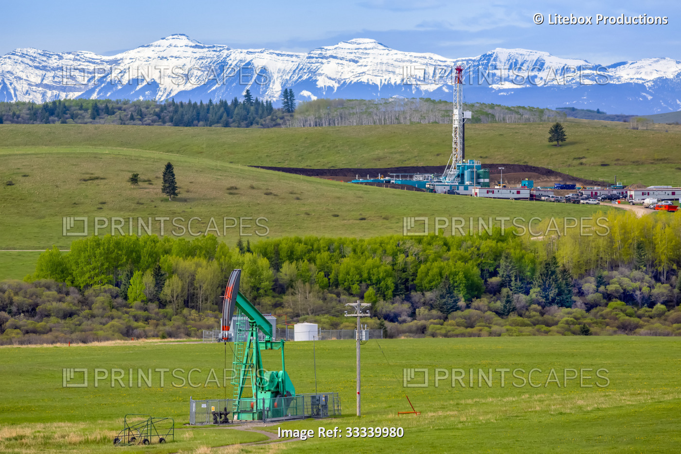 A pumpjack and triple rig drilling equipment sit in the foothills of the ...