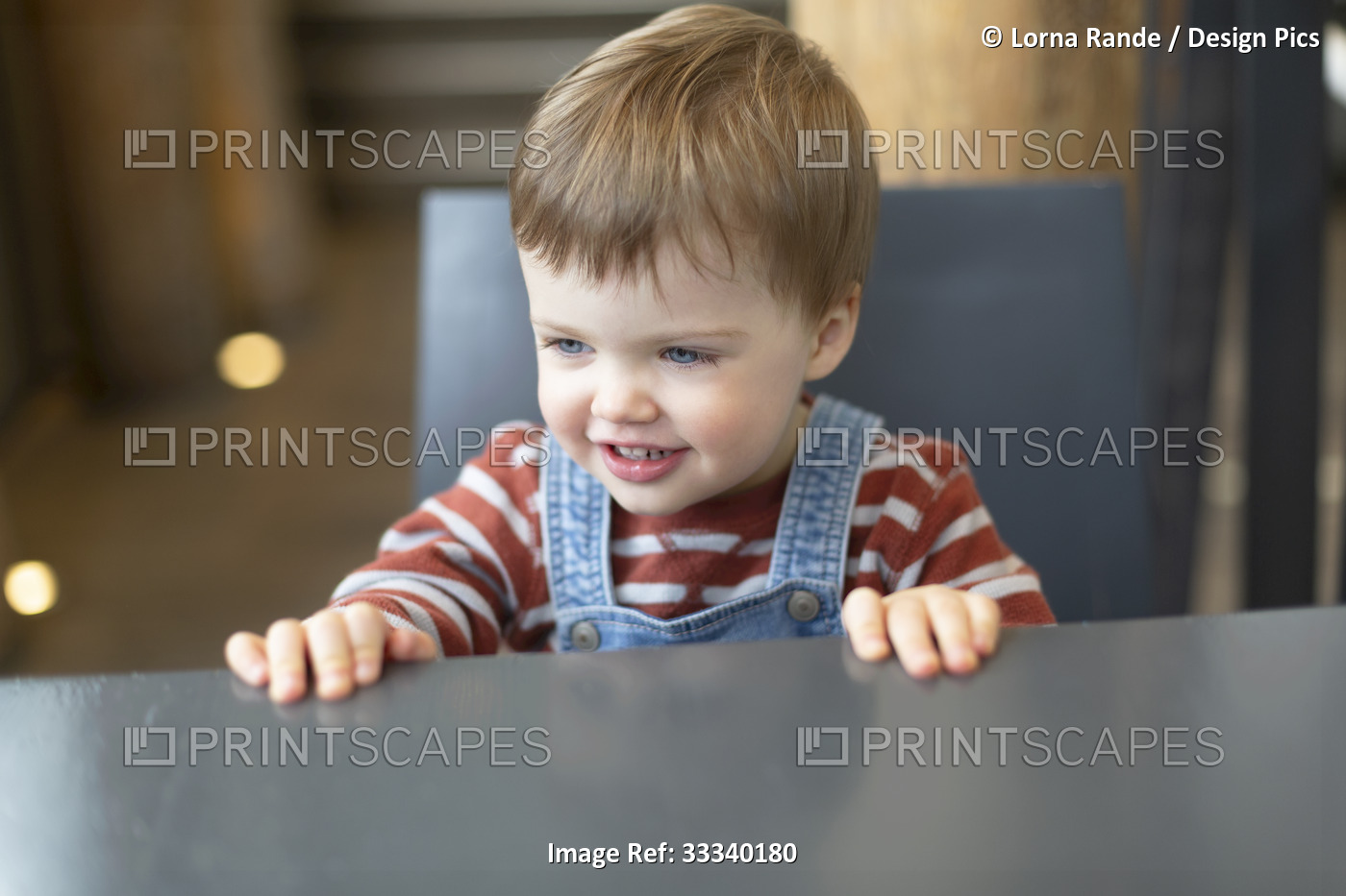 Close-up of toddler girl smiling and sitting at a coffee shop table; North ...