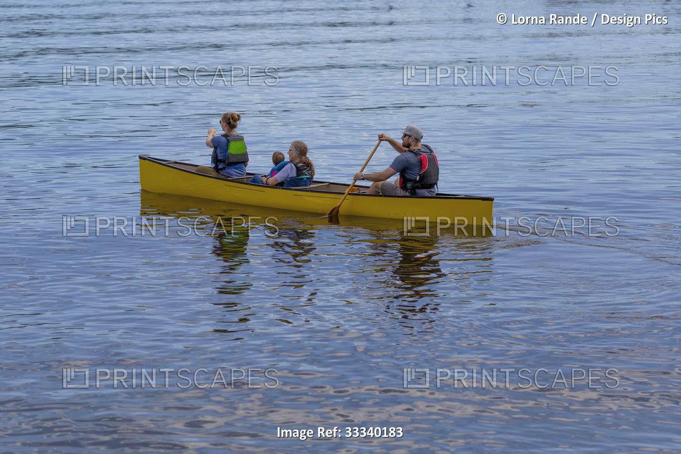 Family canoeing in the calm waters of the bay at Deep Cove; North Vancouver, ...