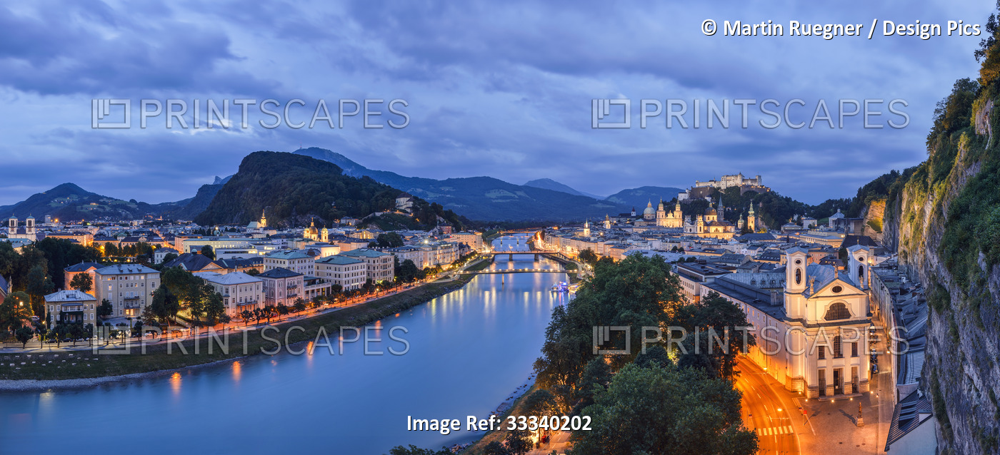 Austrian city of Salzburg at dusk, with the River Salzach reflecting lights; ...