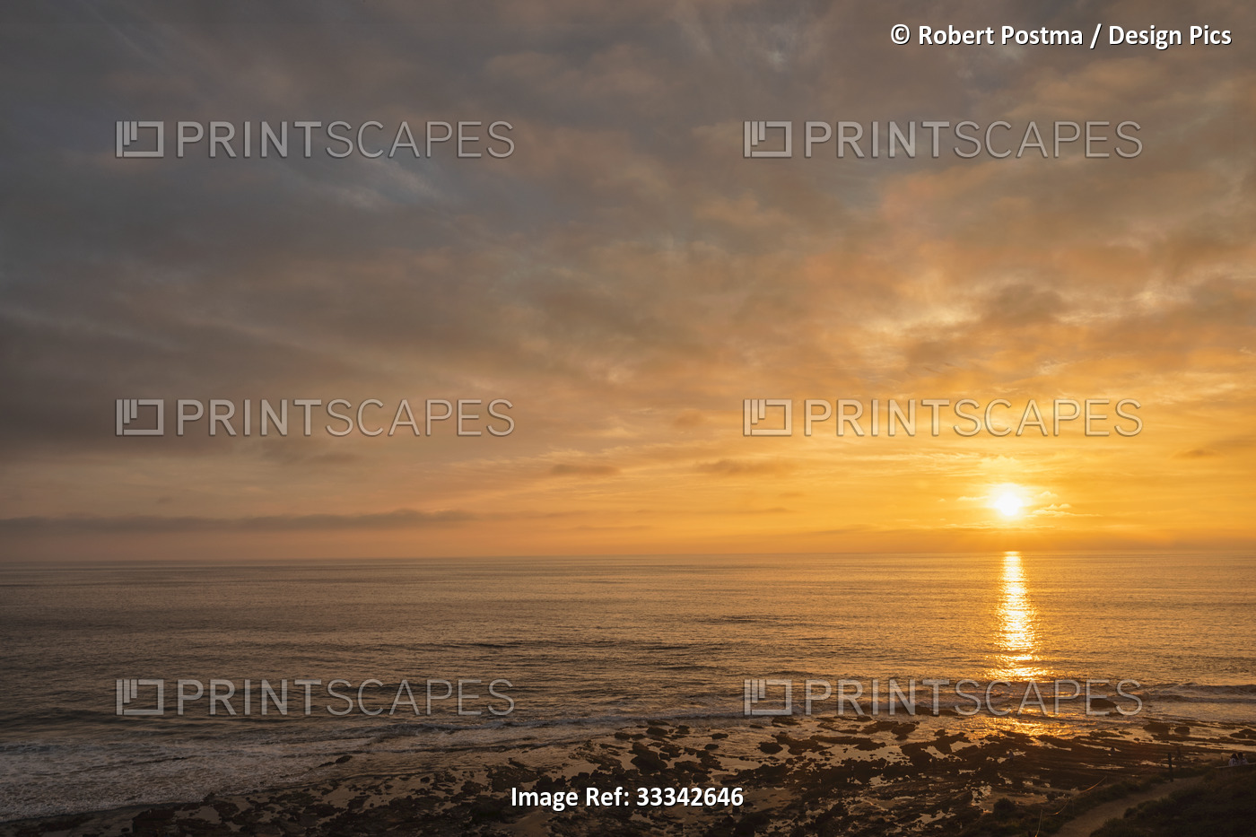 Golden sunset over the shore of an Orange Coast beach; Irvine, Orange County, ...