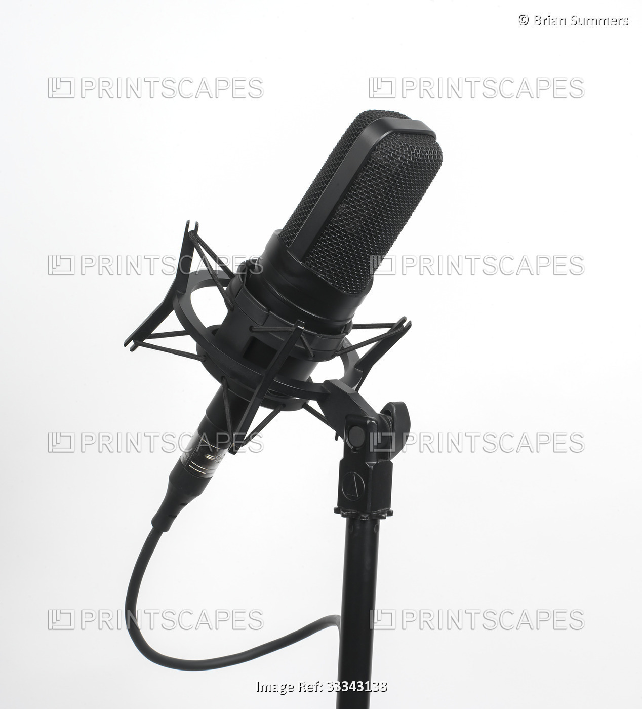 Recording studio microphone with mic cord on a stand on a white background; ...