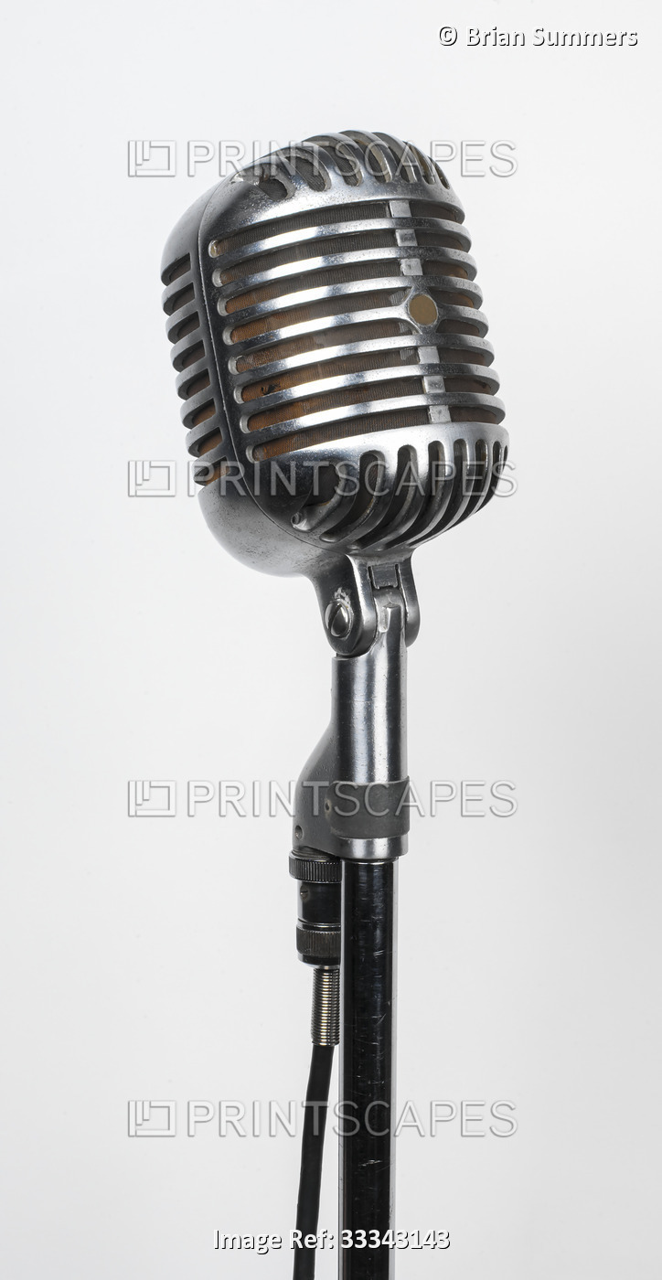 Close-up of a vintage, chrome studio microphone on a stand against a white ...