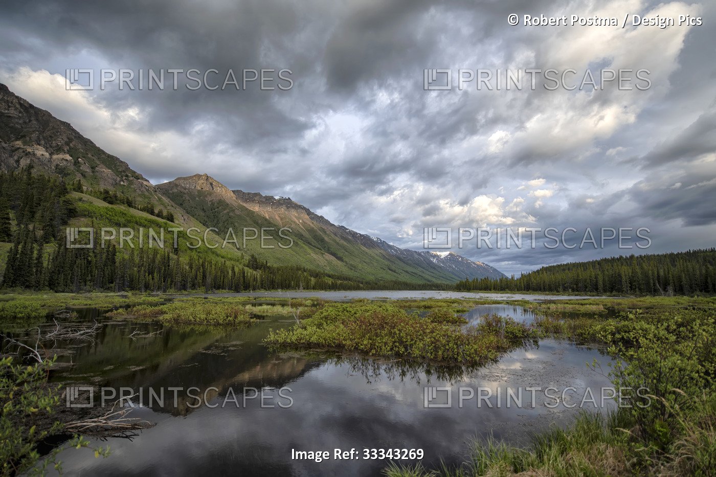 Reflection of mountains and sky in tranquil water at sunset; Whitehorse, Yukon, ...