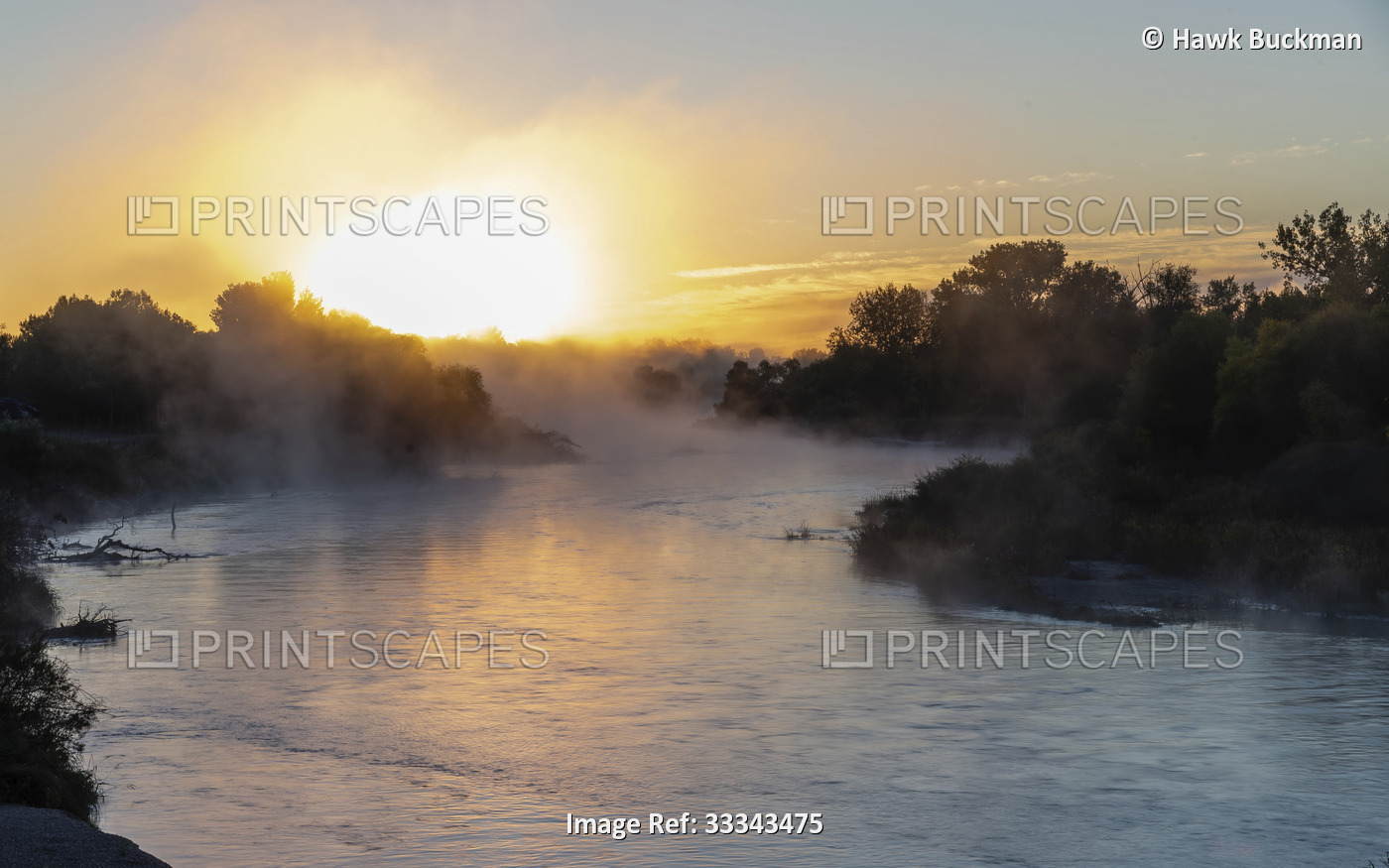 Mist rising off the North Platte River with a glowing sun on the horizon at ...
