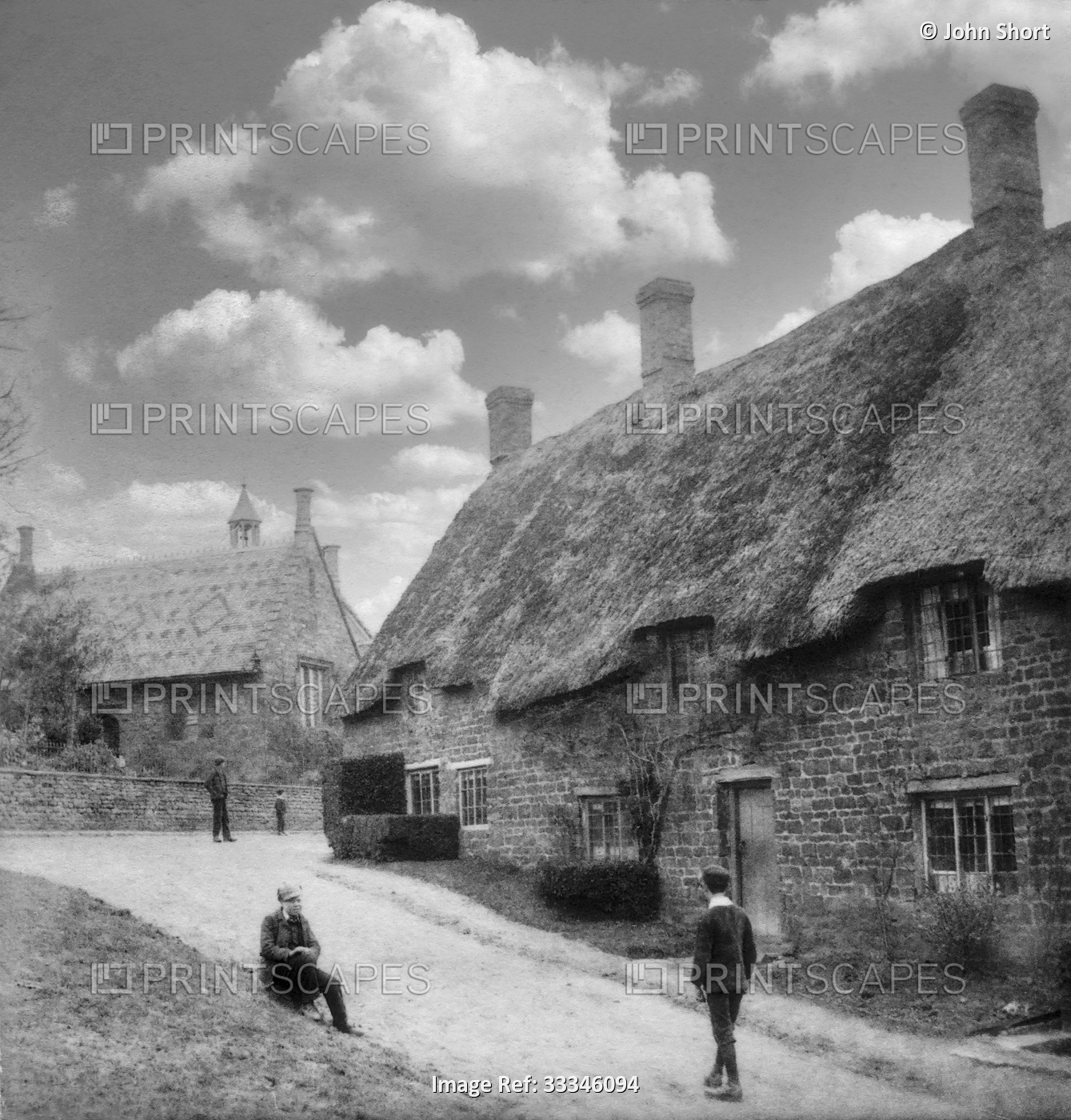 Historic image in black and white of thatched cottages and a church in a ...